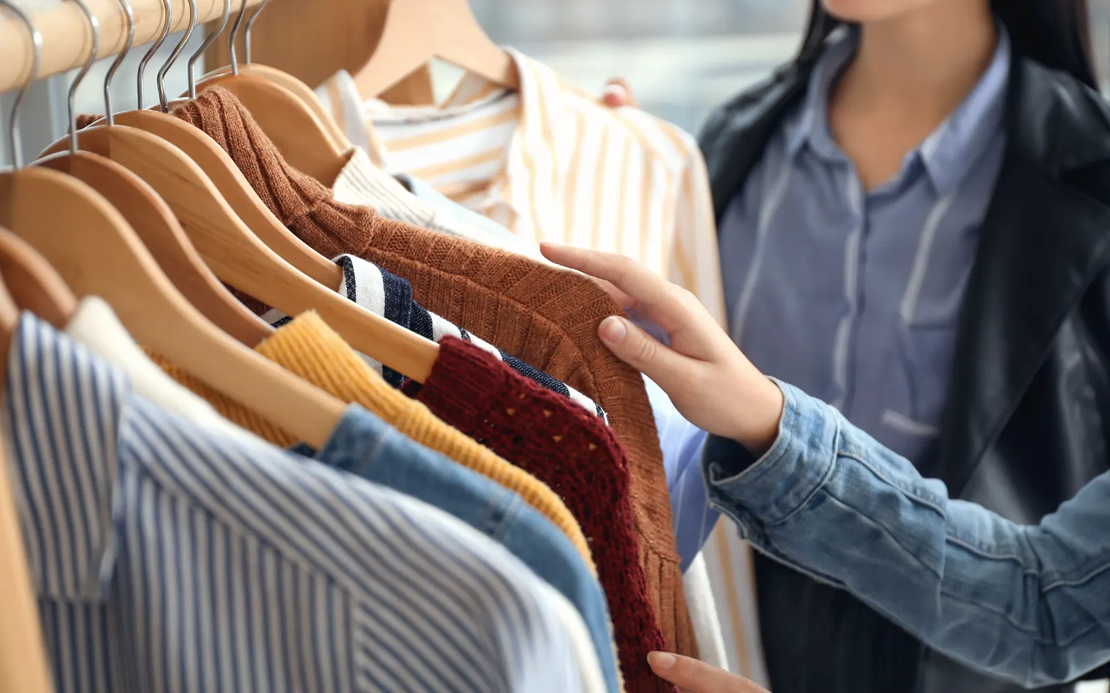 Camisas e roupas sociais penduradas no cabide, sendo conferidas peça por peça